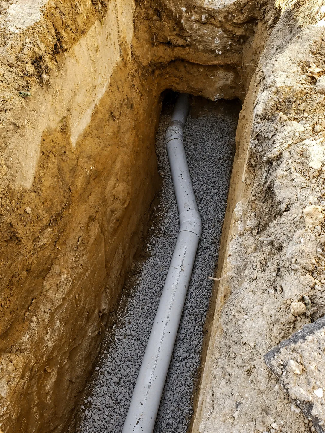New underground sewer line bedded in gravel in a trench